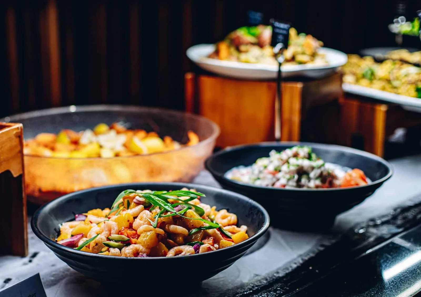 Bowls of kai moana and salads on the Te Puia buffet — prawns, pineapple and fresh herbs