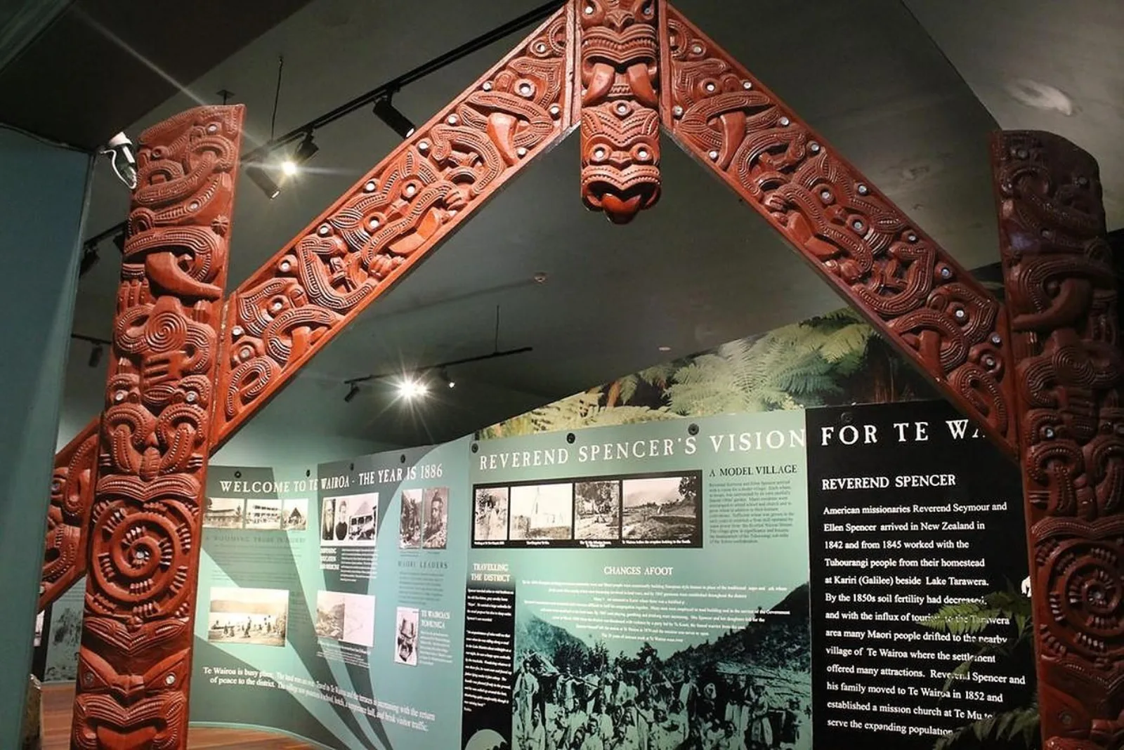 The Buried Village museum interior, with a carved gateway and display panels headed "Welcome to Te Wairoa — the year is 1886"