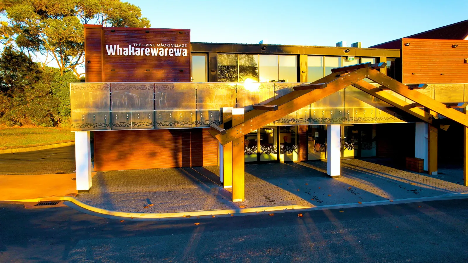 The Whakarewarewa admissions building on Tryon Street at sunrise, signed "The Living Māori Village"