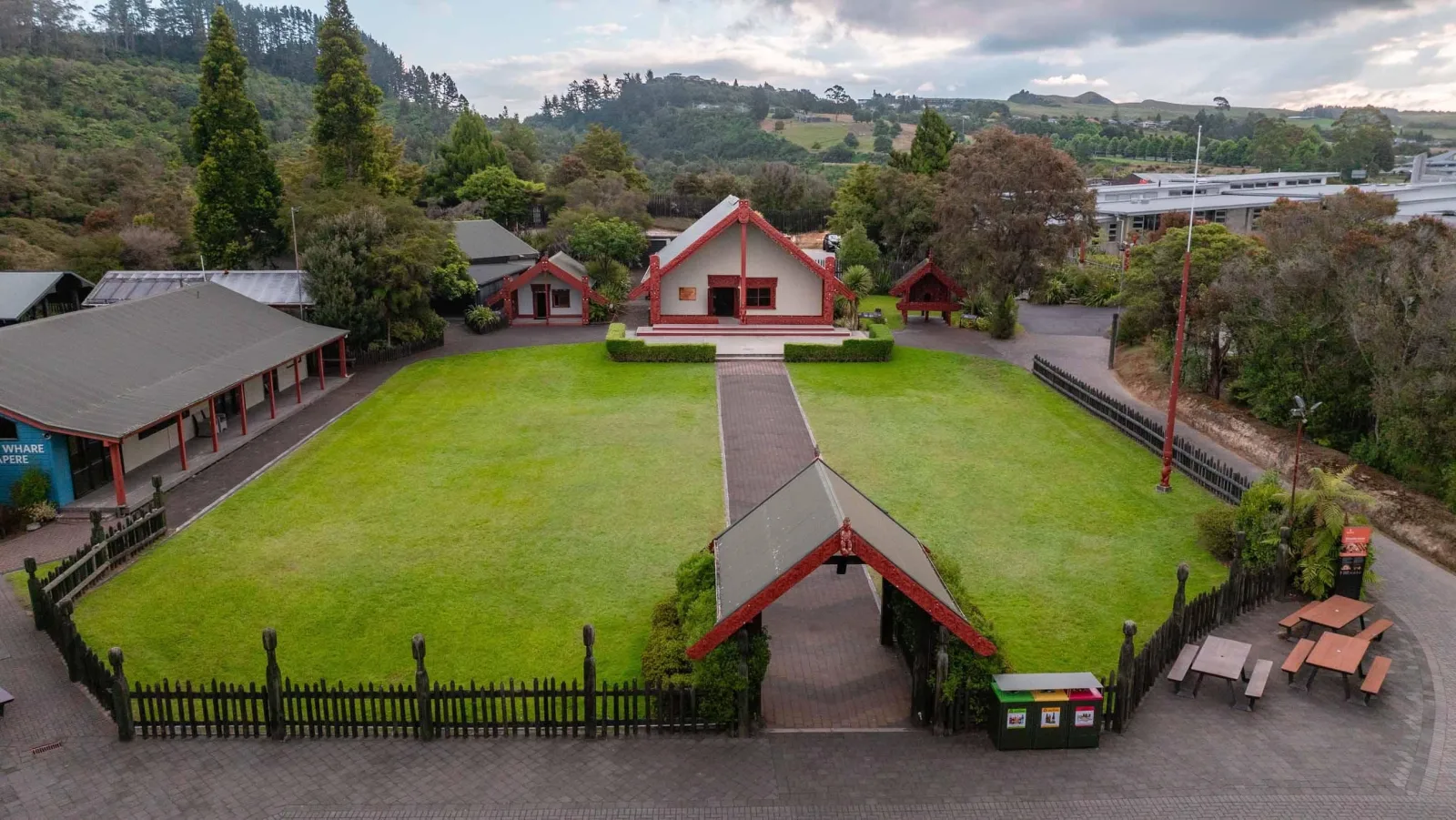 Aerial view of the Te Puia marae complex — the carved meeting house, the open ātea and the palisade